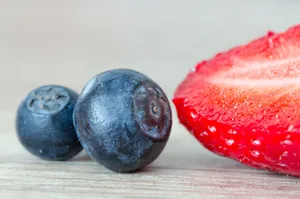 Macro shot of juicy blueberries and a sliced strawberry highlighting freshness and vibrant colors. jigsaw puzzle