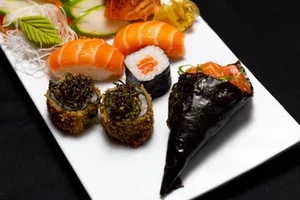 Delicious assorted sushi platter featuring nigiri, maki, and temaki beautifully arranged on a plate. jigsaw puzzle