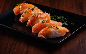 Delicious salmon nigiri sushi served on a sleek black plate with garnishments. jigsaw puzzle