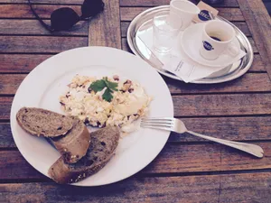 A delicious breakfast of scrambled eggs and bread on a rustic table with coffee cups. jigsaw puzzle