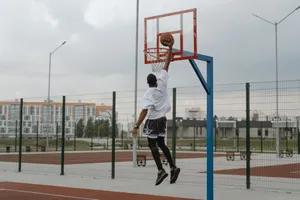 Young man performing an impressive basketball dunk outdoors. jigsaw puzzle