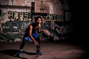 Young man dribbling a basketball on a graffiti-covered court, showcasing street sport style. jigsaw puzzle