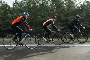 Three men cycling together on a scenic outdoor road, showcasing teamwork and athleticism. jigsaw puzzle