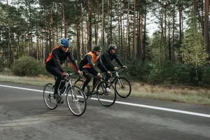 Three cyclists pedal on a forest road, engaging in outdoor sports and recreation. jigsaw puzzle