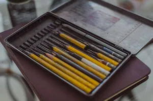 A neatly organized set of colorful art pencils inside a metal case, perfect for artists. jigsaw puzzle