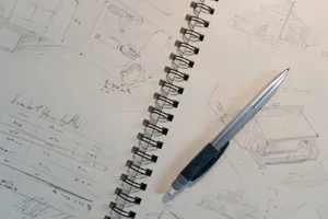 Explore detailed architectural sketches and designs on a spiral notepad with a mechanical pencil. jigsaw puzzle