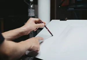 Close-up of hands sketching a cylinder on paper in a Shinjuku art studio. jigsaw puzzle