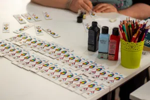 Close-up of crafting setup with playing cards, paints, and pencils on a table. jigsaw puzzle