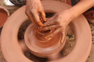 A detailed look at hands shaping clay on a spinning pottery wheel. jigsaw puzzle