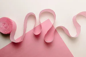 Stylized pink paper streamer and sheet on a neutral backdrop, ideal for party and craft themes. jigsaw puzzle