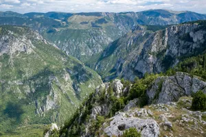 Lush green canyon with rocky cliffs under sky jigsaw puzzle