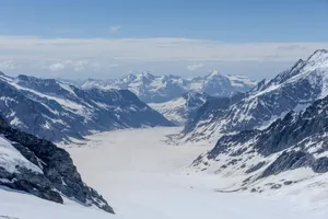 A view of a snowy mountain range from the top of a mountain jigsaw puzzle