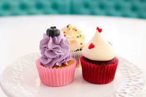 a white plate topped with three cupcakes covered in frosting jigsaw puzzle