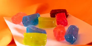 A bunch of gummy bears sitting on top of a white plate jigsaw puzzle