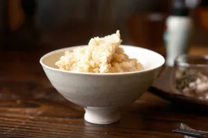 a white bowl filled with rice on top of a wooden table jigsaw puzzle