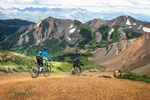 man in blue jacket riding bicycle on dirt road during daytime jigsaw puzzle
