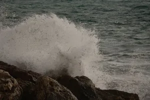 Powerful ocean wave crashing dramatically against a rocky shoreline, showcasing nature's raw energy. jigsaw puzzle