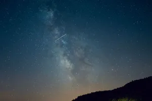 A breathtaking view of a starry sky featuring the Milky Way and a meteor streaking across. jigsaw puzzle