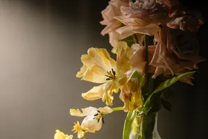 Beautiful floral arrangement with softly lit pink roses and yellow tulips in a vase. jigsaw puzzle