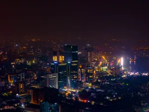 Aerial view of a bustling city skyline at night with brightly illuminated skyscrapers and streets. jigsaw puzzle
