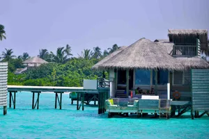 Idyllic overwater bungalow surrounded by turquoise waters and palm trees in the Maldives. jigsaw puzzle