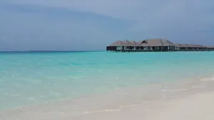 Serene tropical beach scene with turquoise water and thatched roof bungalows in Maldives. jigsaw puzzle