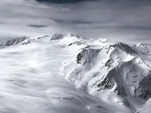 A breathtaking view of snow-capped mountains under dramatic skies in Austria. jigsaw puzzle