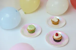 Three delicious cupcakes served on plates with colorful balloons, perfect for celebrations. jigsaw puzzle