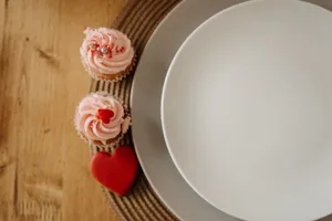 A charming still life of heart-shaped cupcakes on a dining table setting, perfect for Valentine's decor. jigsaw puzzle