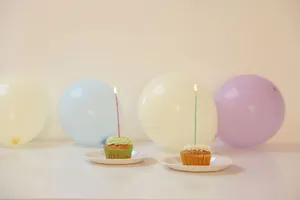 Vibrant cupcakes with lit candles surrounded by balloons, perfect for celebrations. jigsaw puzzle