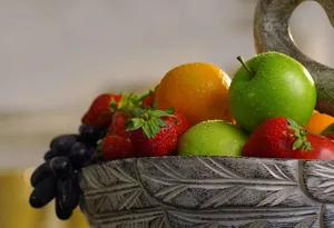 Close-up of assorted fresh fruits like apples, oranges, and strawberries in a ceramic bowl. jigsaw puzzle