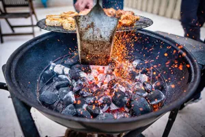 Close-up view of a barbecue grill with glowing charcoal and sizzling meats, igniting a vibrant cooking scene. jigsaw puzzle