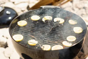 Smoky outdoor barbecue with lemon slices grilling on a circular charcoal grill. jigsaw puzzle