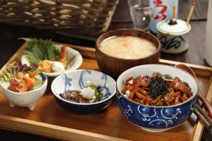 A beautifully arranged Japanese meal featuring rice bowl, miso soup, and side dishes on a wooden tray. jigsaw puzzle