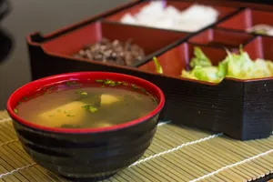 Close-up of a traditional Japanese bento box featuring a bowl of miso soup and various side dishes. jigsaw puzzle