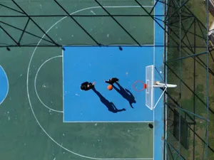 Top-down aerial view of two men playing basketball on an outdoor court. jigsaw puzzle