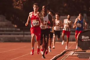 Group of athletes competing in a track and field race on an outdoor track under sunlight. jigsaw puzzle