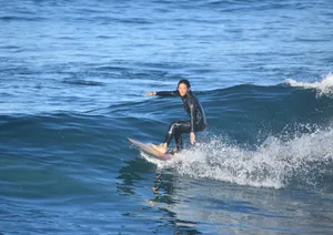 A female surfer skillfully rides a wave in a calm ocean setting, showcasing balance and control. jigsaw puzzle