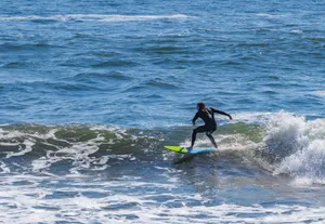 A surfer expertly navigates a wave, showcasing skillful balance and enjoyment in the ocean. jigsaw puzzle