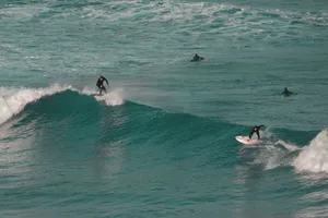Surfers riding ocean waves capture thrill of surfing at a vibrant coastal location. jigsaw puzzle