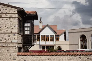 Explore the diverse architectural styles of Elazığ with traditional stone and wood houses under a dramatic sky. jigsaw puzzle