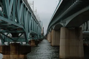 A steel bridge spans a waterway in Tokyo, showcasing modern architectural engineering. jigsaw puzzle