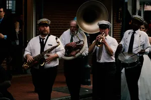 A lively street parade featuring a jazz band playing brass instruments in a festive outdoor setting. jigsaw puzzle