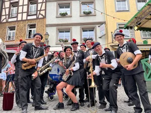 Dynamic street band with diverse musicians performing in a festive urban setting. jigsaw puzzle