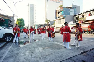 Musicians in red uniforms performing in a lively street parade. jigsaw puzzle