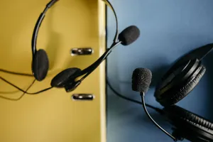 Close-up of headphones with attached microphones on a vibrant yellow and blue background, perfect for tech-related content. jigsaw puzzle