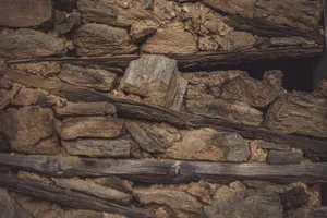 Detailed view of a textured stone and wood wall showcasing natural rustic materials. jigsaw puzzle