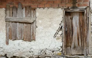 Old wooden gate and window on a weathered stone wall with exposed bricks, showcasing rustic and vintage architecture. jigsaw puzzle