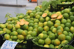 A vibrant display of fresh green tangerines at an outdoor market, showcasing vibrant citrus appeal. jigsaw puzzle