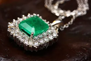 Stunning emerald pendant necklace in white gold with shimmering diamonds, epitomizing luxury and elegance. jigsaw puzzle